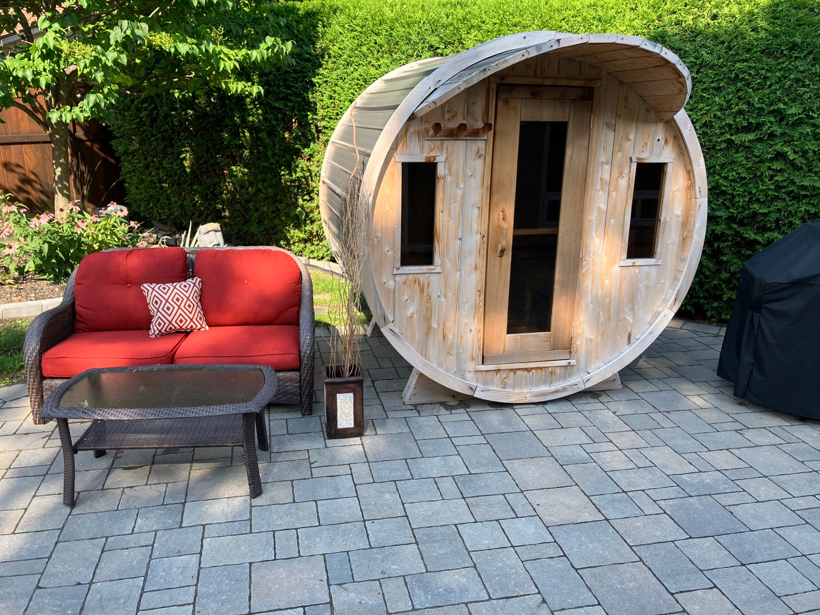 Brad's cedar barrel sauna in his landscaped backyard during summer