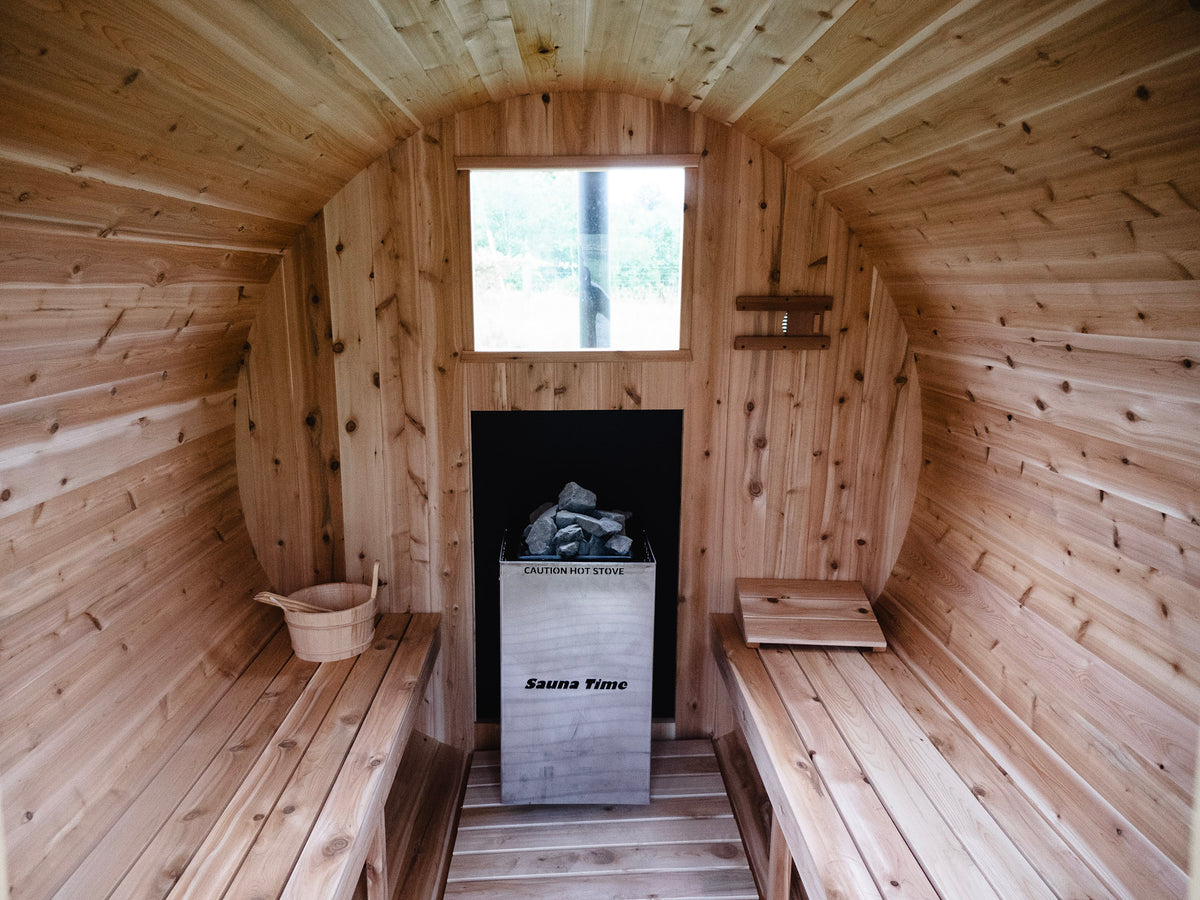 Inside a cedar sauna, with bench seating and a stove